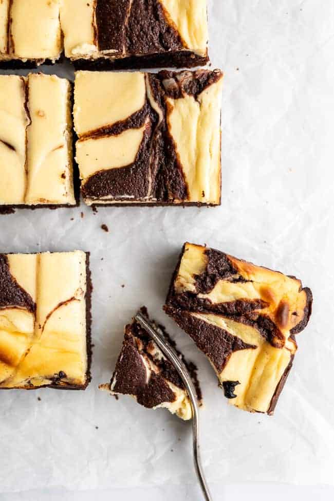 cheesecake brownie with a fork slicing a quarter out.