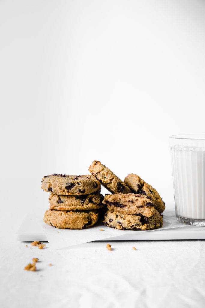 keto pumpkin chocolate chip cookies with milk on white background